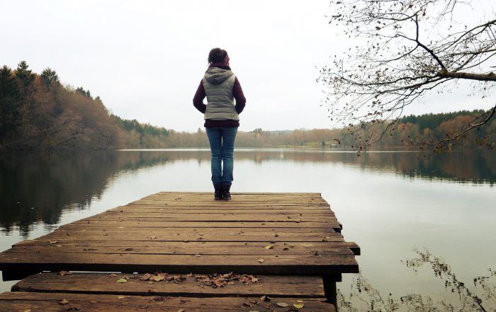 Woman standing next to lake.