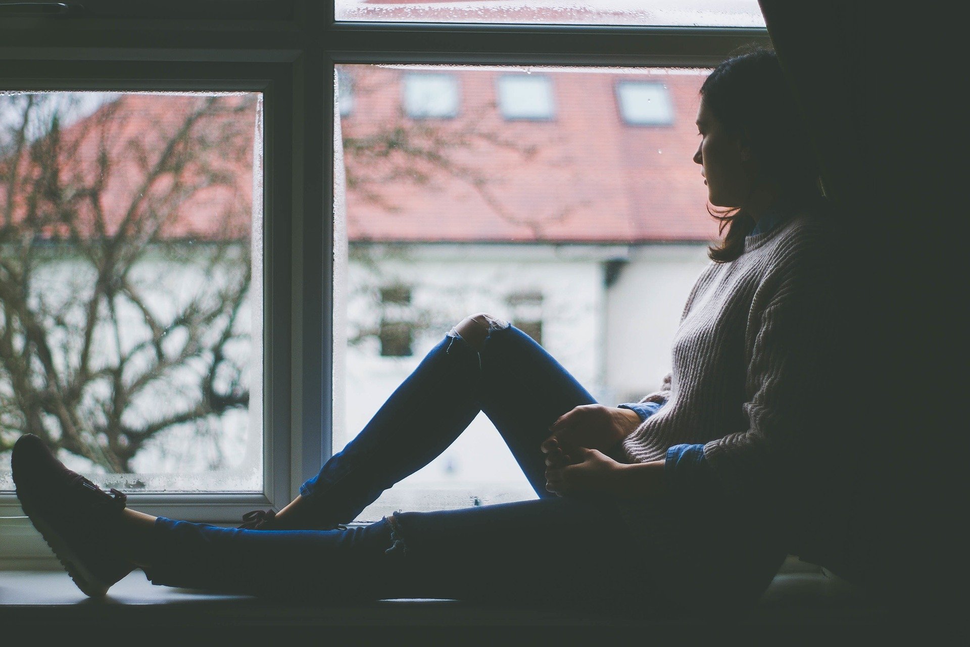 woman sat by window, winter, seasonal affective disorder